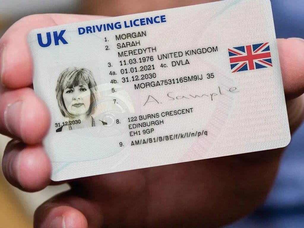 Licencia de conducir británica (UK driving licence) en la mano de una persona